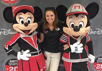 young woman stands between Minnie Mouse and Mickey Mouse life-sized mascots|||