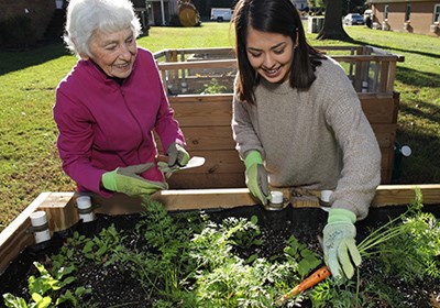 |Photo of Jacqueline Lamas|Older person and younger person work together in a garden