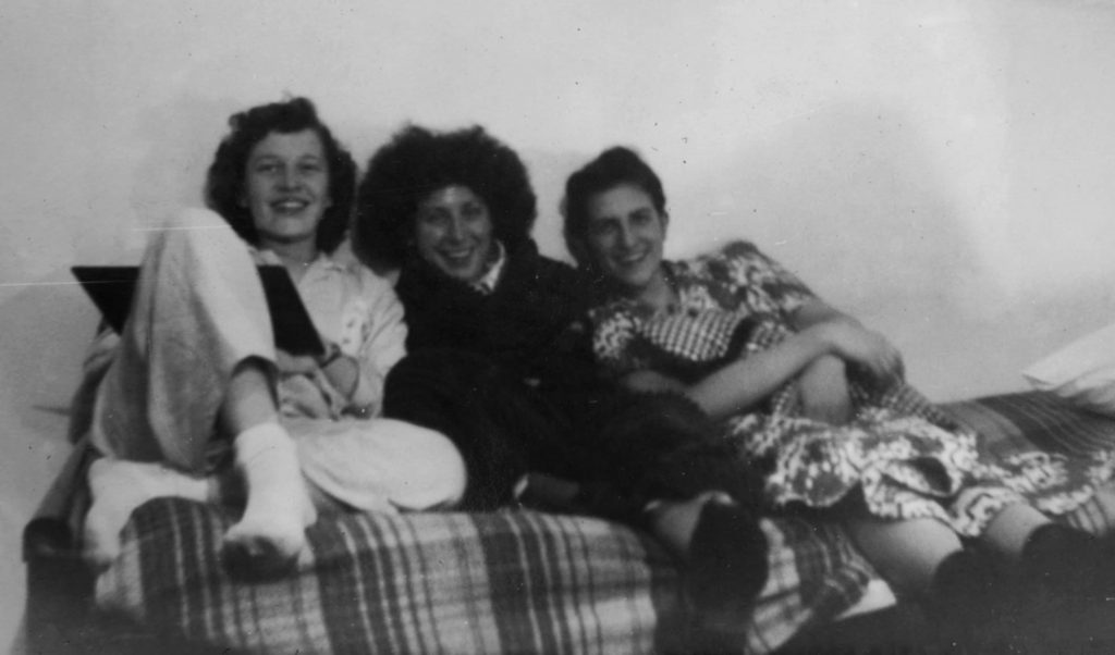 Black and white photo of three women sitting together on a couch