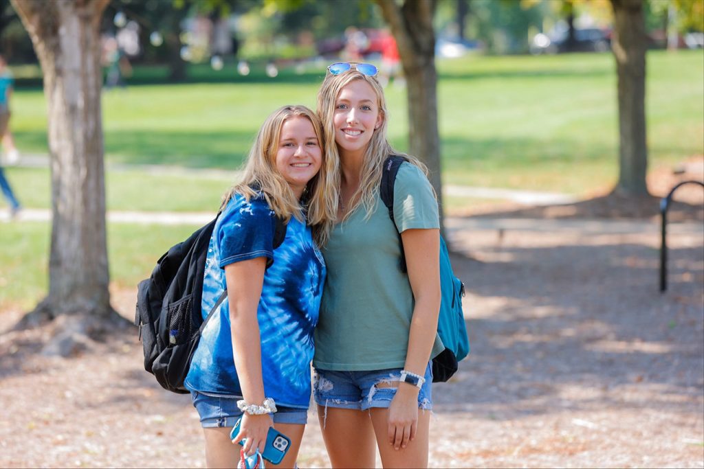 Two girls hug and smile on the first day of classes 2021