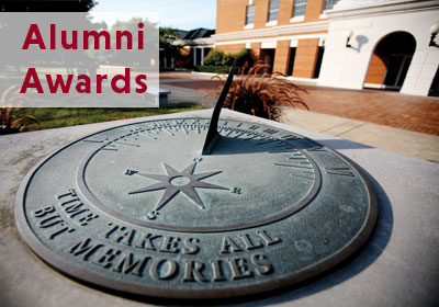 A sundial that reads "time takes all but memories" with the words "alumni awards" in the corner