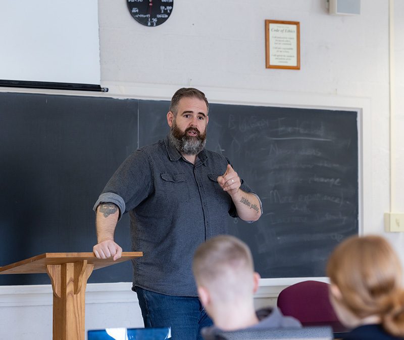 Professor at the front of the classroom teaching students