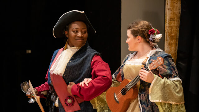 Two actresses during performance wearing colonial clothing