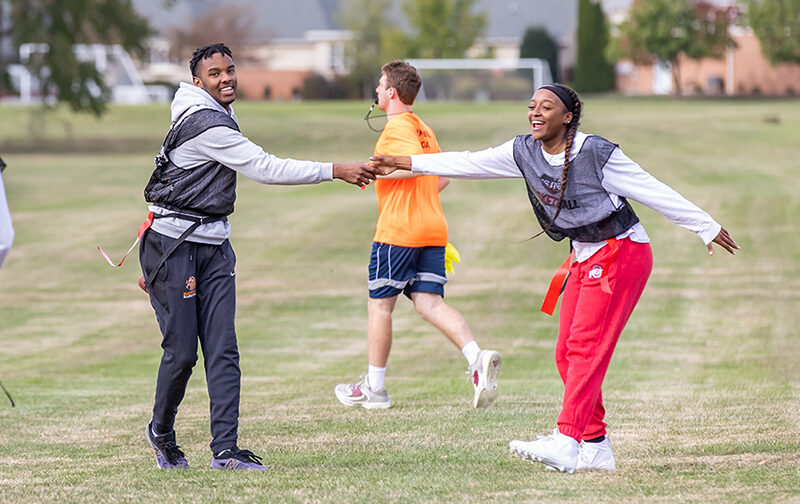 Boy and girl high-fiving during a flag football