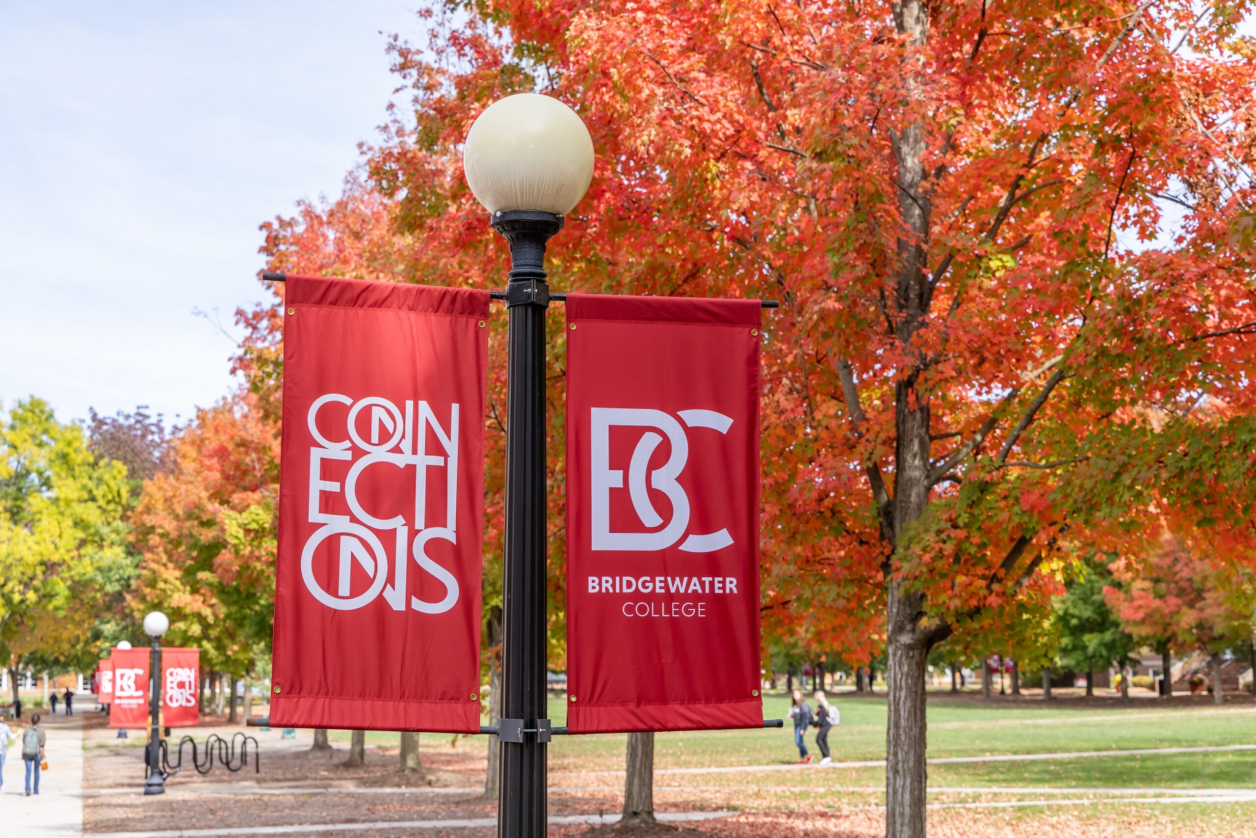 red banners that read B-C Bridgewater College and Connections. A fall tree is behind the banners