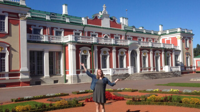 Student posing for photo in front of a building in Finland