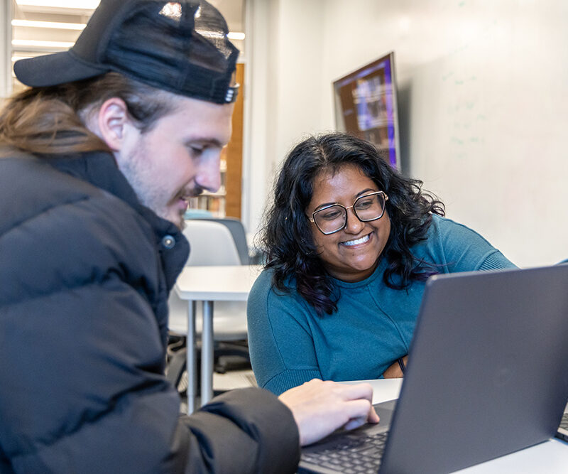 Two students looking at a laptop