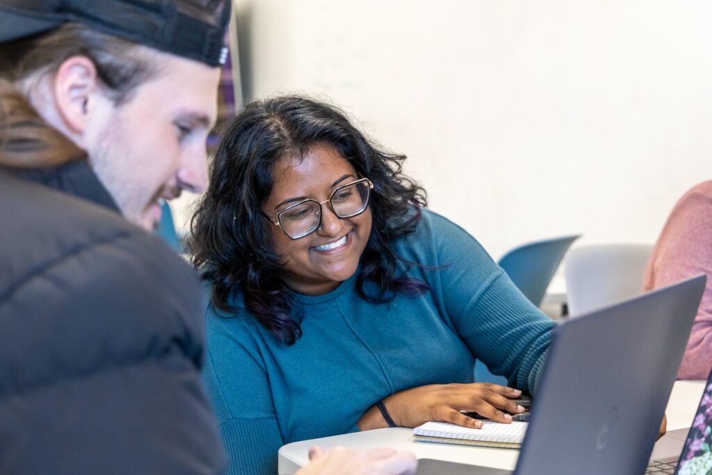 Two students looking at a laptop