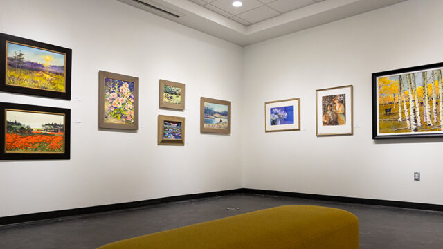 Paintings displayed on the white walls of the Beverly Perdue Art Gallery