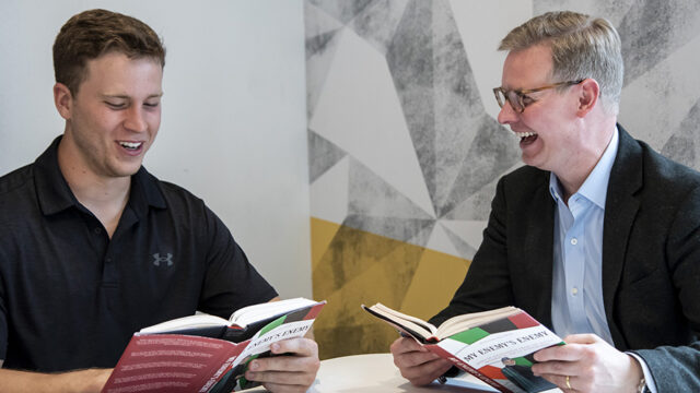 Alex Schwind '22 and Brandon Marsh sitting discussing a book they are both holding