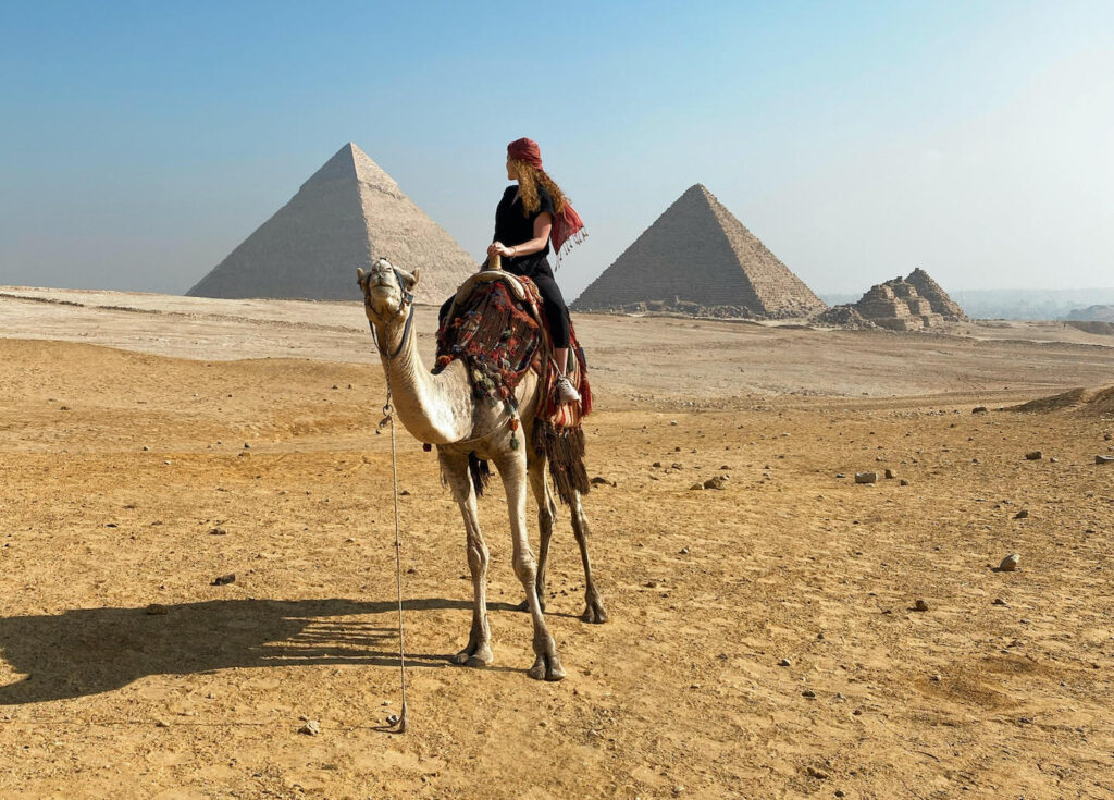 Study abroad participant in Egypt with pyramids in background.