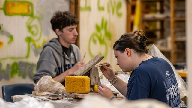 Two students working on projects in a ceramics art class