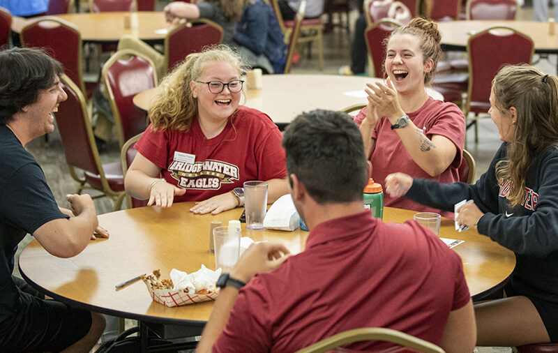 Students sitting at a dining table laughing and having fun