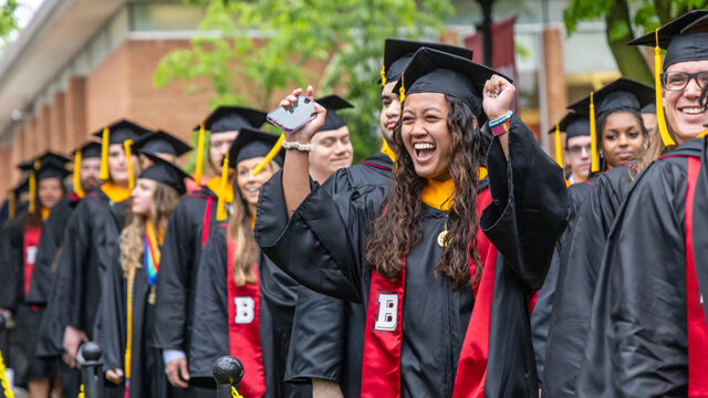 Girl cheering in line of graduates at commencement