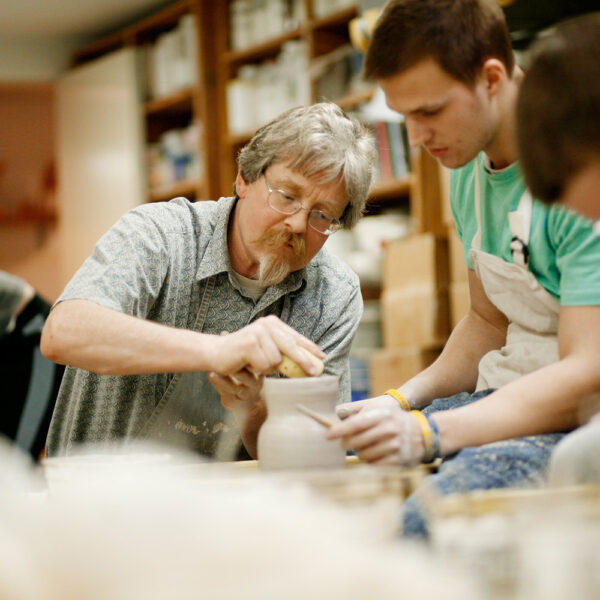 Professor Michael Hough working with student at pottery wheel