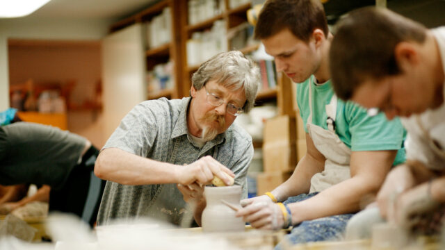 Professor Michael Hough working with student at pottery wheel