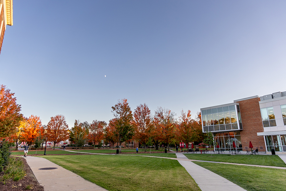 Bridgewater College campus at dusk in the fall with red and gold leaves on the trees