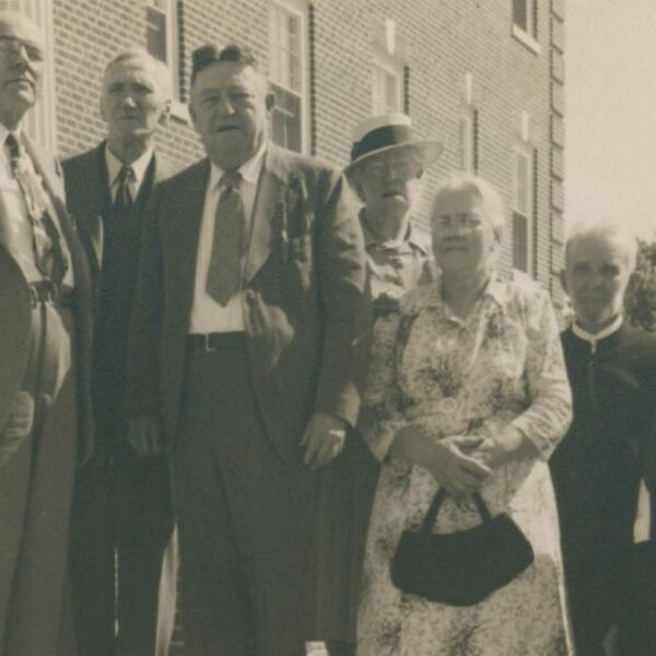 Group of seven alumni from the Class of 1899 standing on stairs.