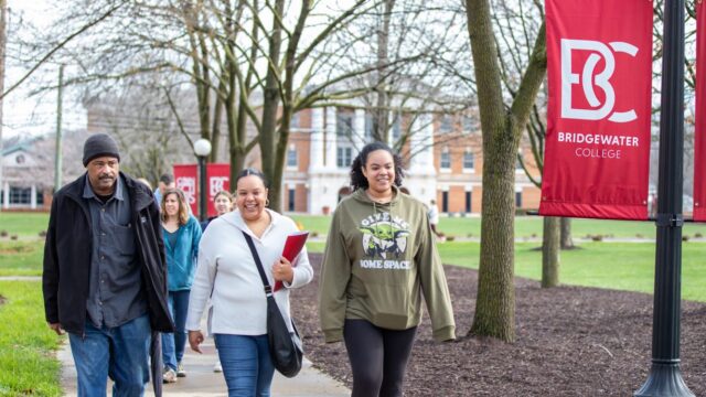 A visiting family walk along the campus mall on a tour