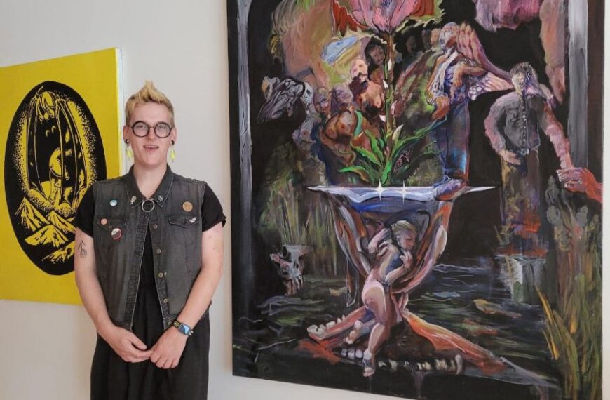 Aurora Powell standing in front of their art.