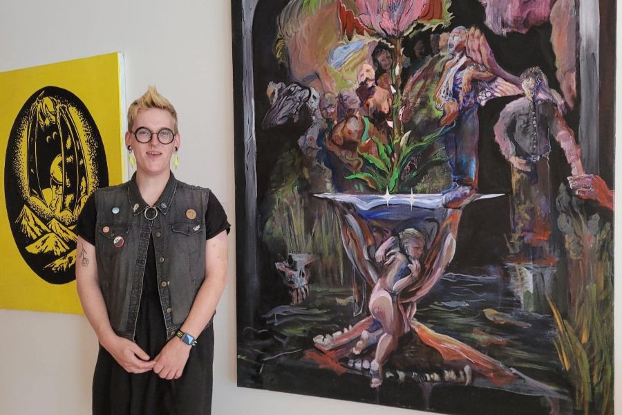 Aurora Powell standing in front of their art.